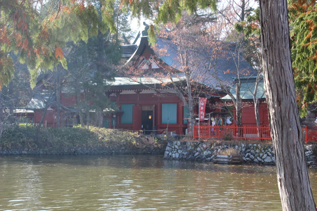 神池の対岸から望む生島足島神社の池心の宮と周囲の木々