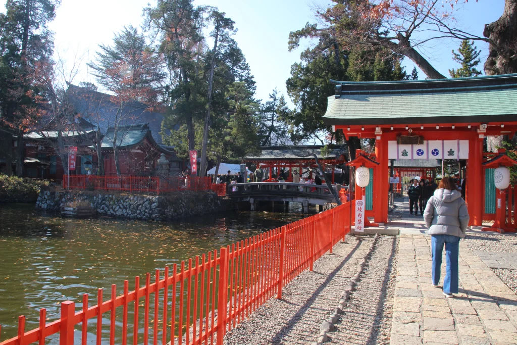 生島足島神社の神門へと続く参道と、傍らに立つ大きな御神木の風景