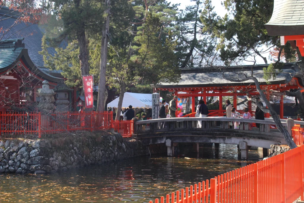 七五三の参拝客などで賑わう生島足島神社の神池に架かる反り橋（御神橋）