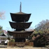 広々とした境内の敷地と木々の中心に佇む前山寺三重塔の広角写真
