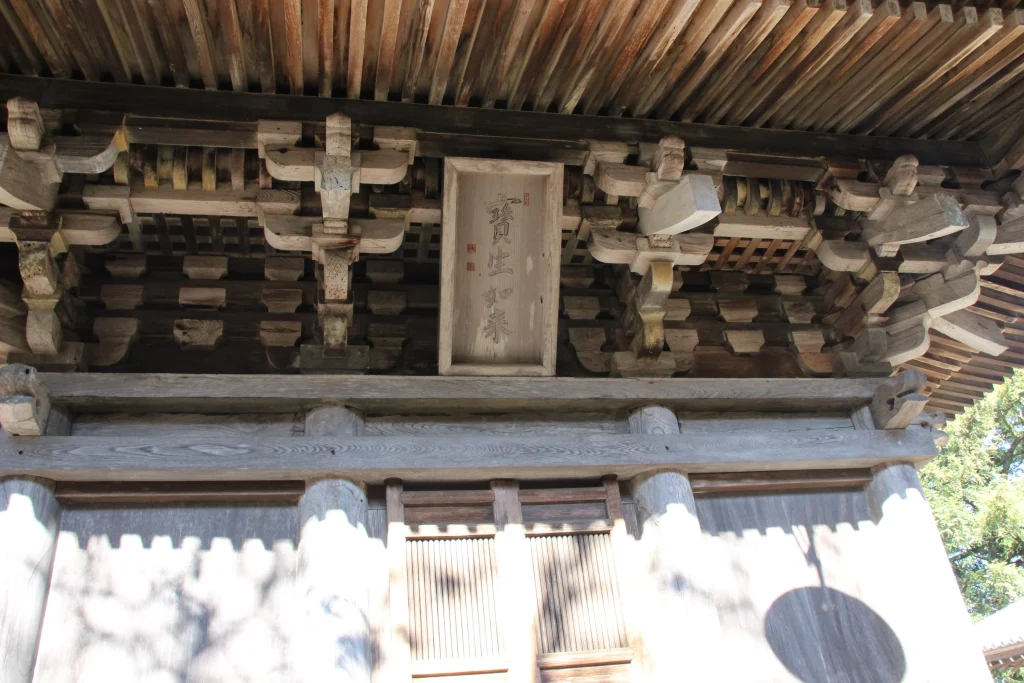 三重塔の正面扉の上に掲げられた木製扁額『寶生如来』