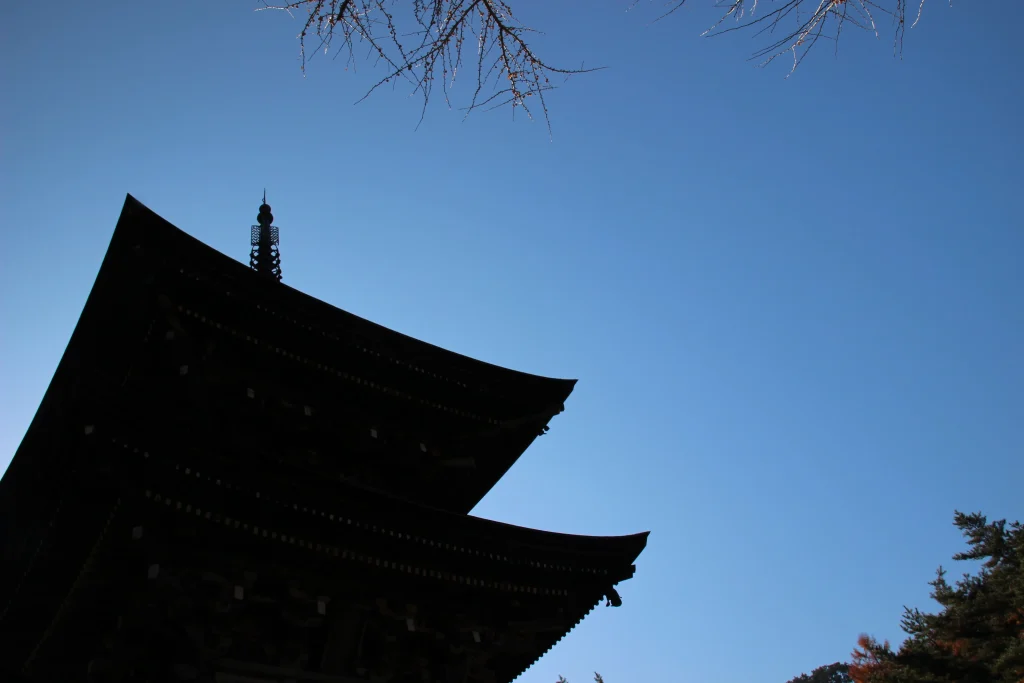 澄んだ青空を切り取るようにそびえる三重塔の美しい屋根のシルエット