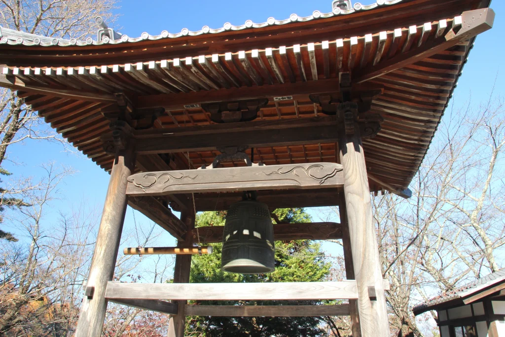 美しい瓦屋根を冠した前山寺の木造鐘楼と吊るされた立派な梵鐘