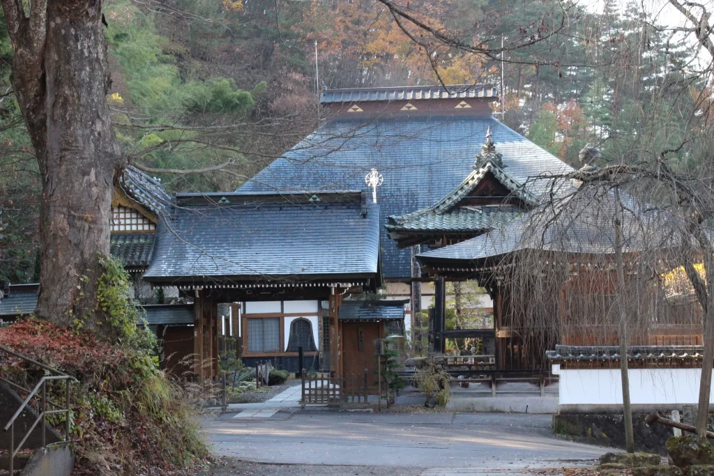 歴史ある茅葺き屋根の山門(黒門)とその奥に広がる曹洞宗龍光院の本堂と境内の全景