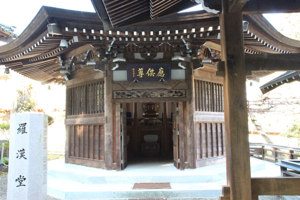 手前の門柱をフレームにして遠景に佇む羅漢堂の姿を捉えた情緒あるアングル