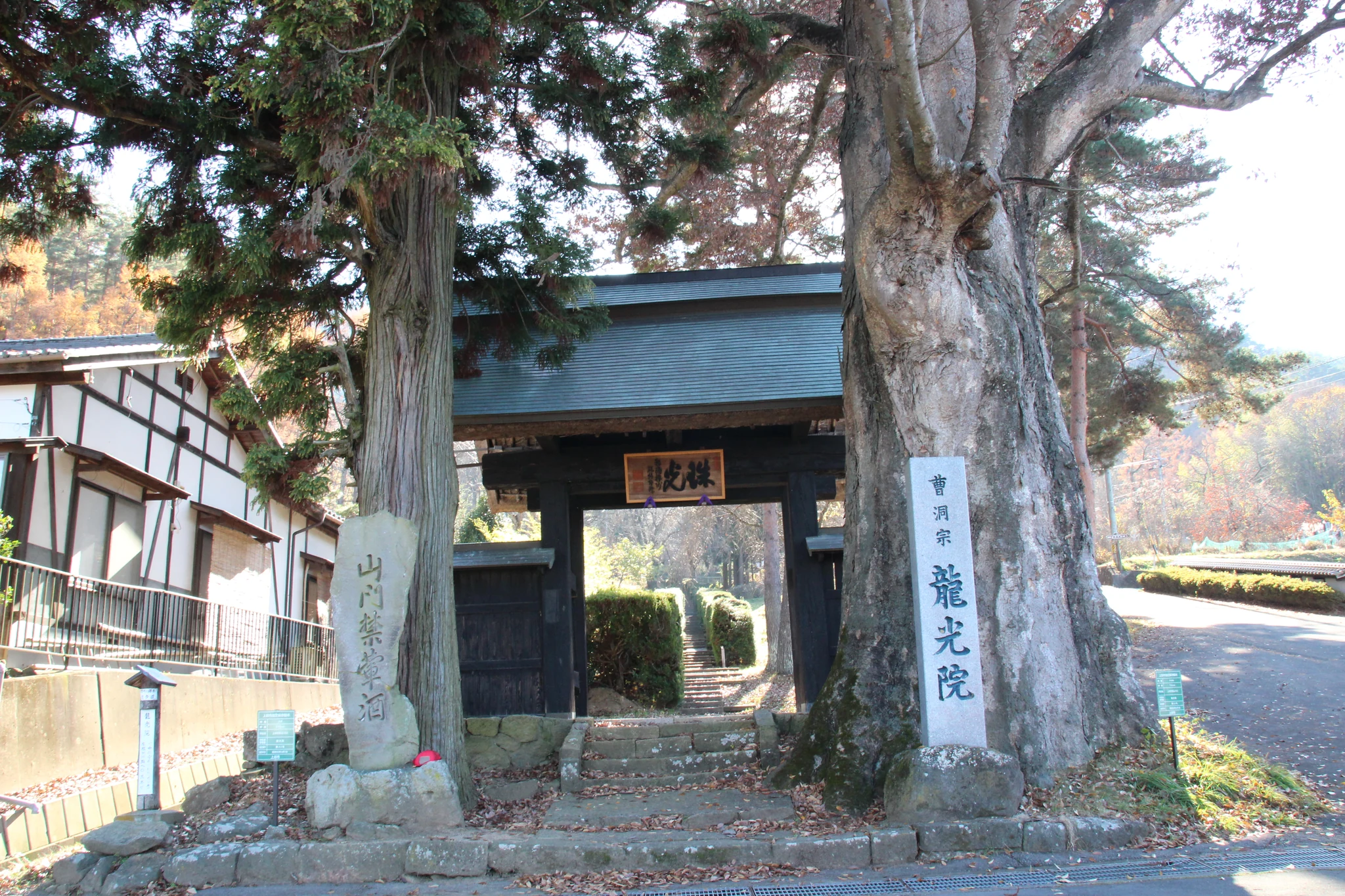 重厚な黒い門柱と梁で組まれた歴史深い龍光院山門（黒門）の正面写真