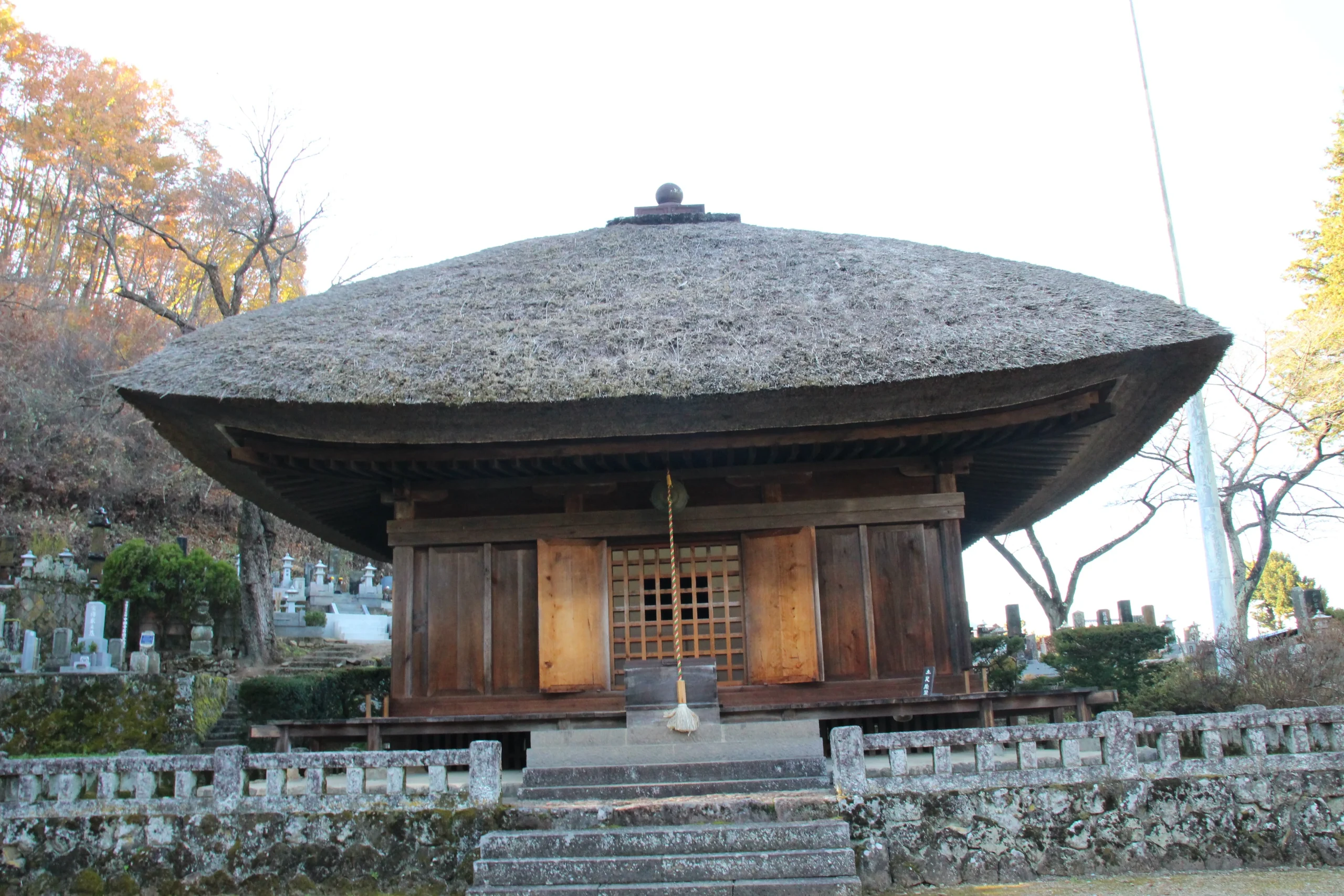 高い石垣と古びた石段の上に威風堂々と建つ中禅寺薬師堂의正面全景