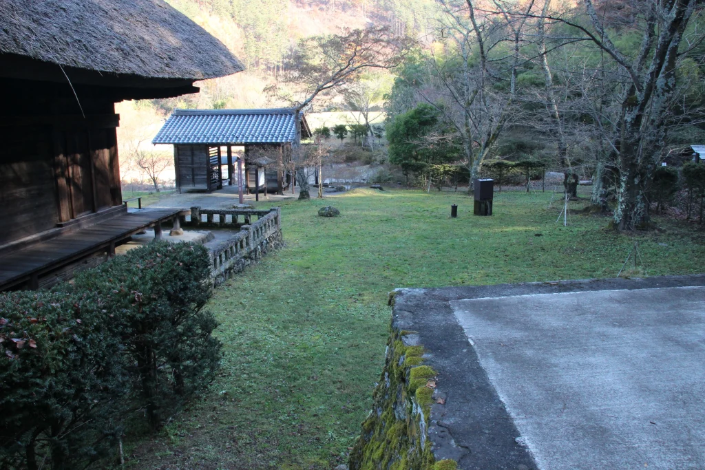 中禅寺薬師堂の縁側から見下ろす美しい芝生庭園と奥の建物
