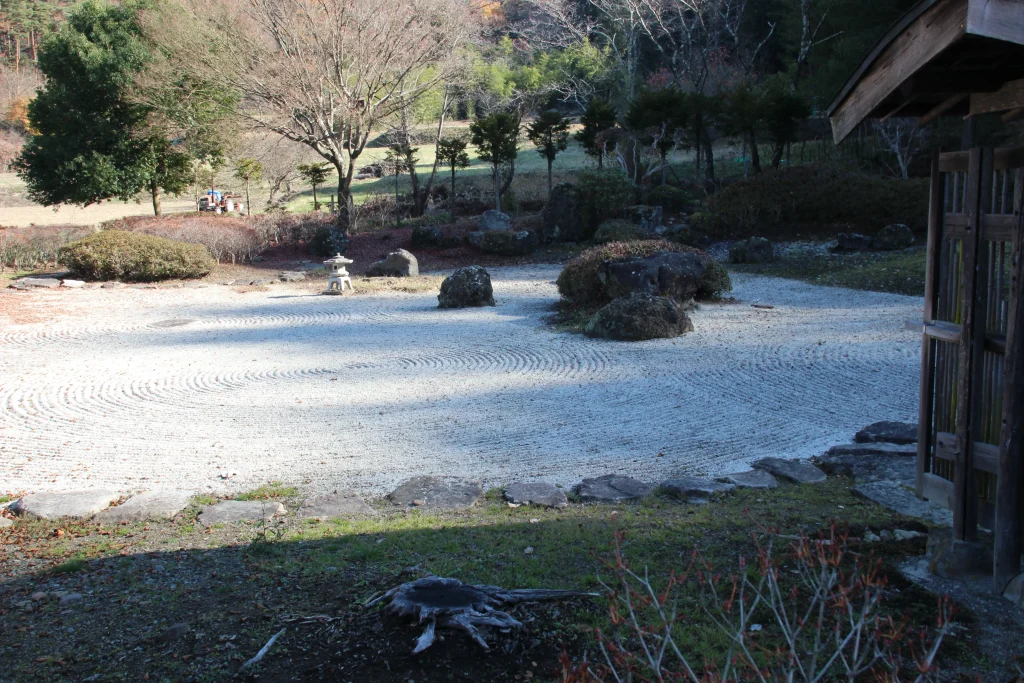 中禅寺の枯山水庭園。白砂に見事な砂紋が描かれ、信州の自然と石組が調和する静寂の空間です。