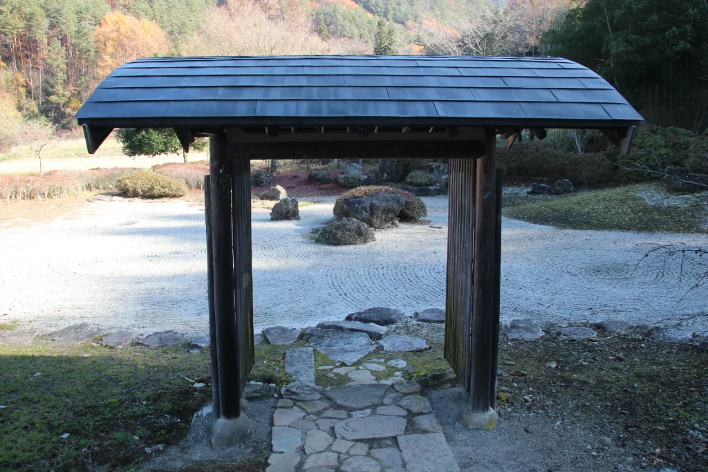 石畳の小路から門の奥に広がる枯山水庭園を見渡す。長野の豊かな自然と歴史ある山寺が織りなす癒しの絶景です。
