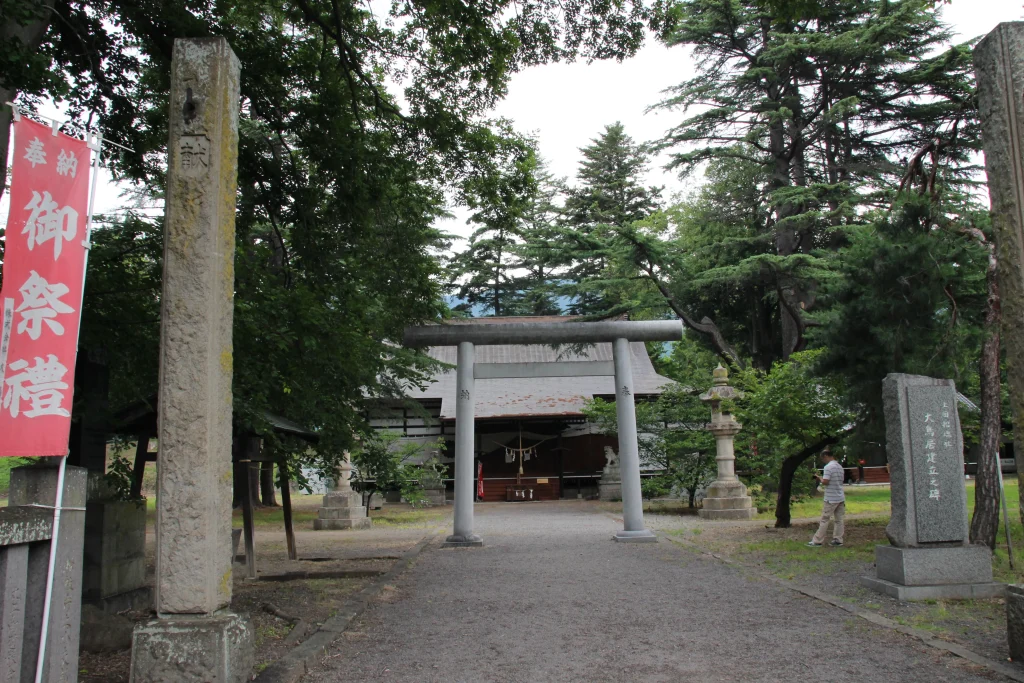 石鳥居と「御祭禮」ののぼり旗が迎える上田招魂社の参道と境内
