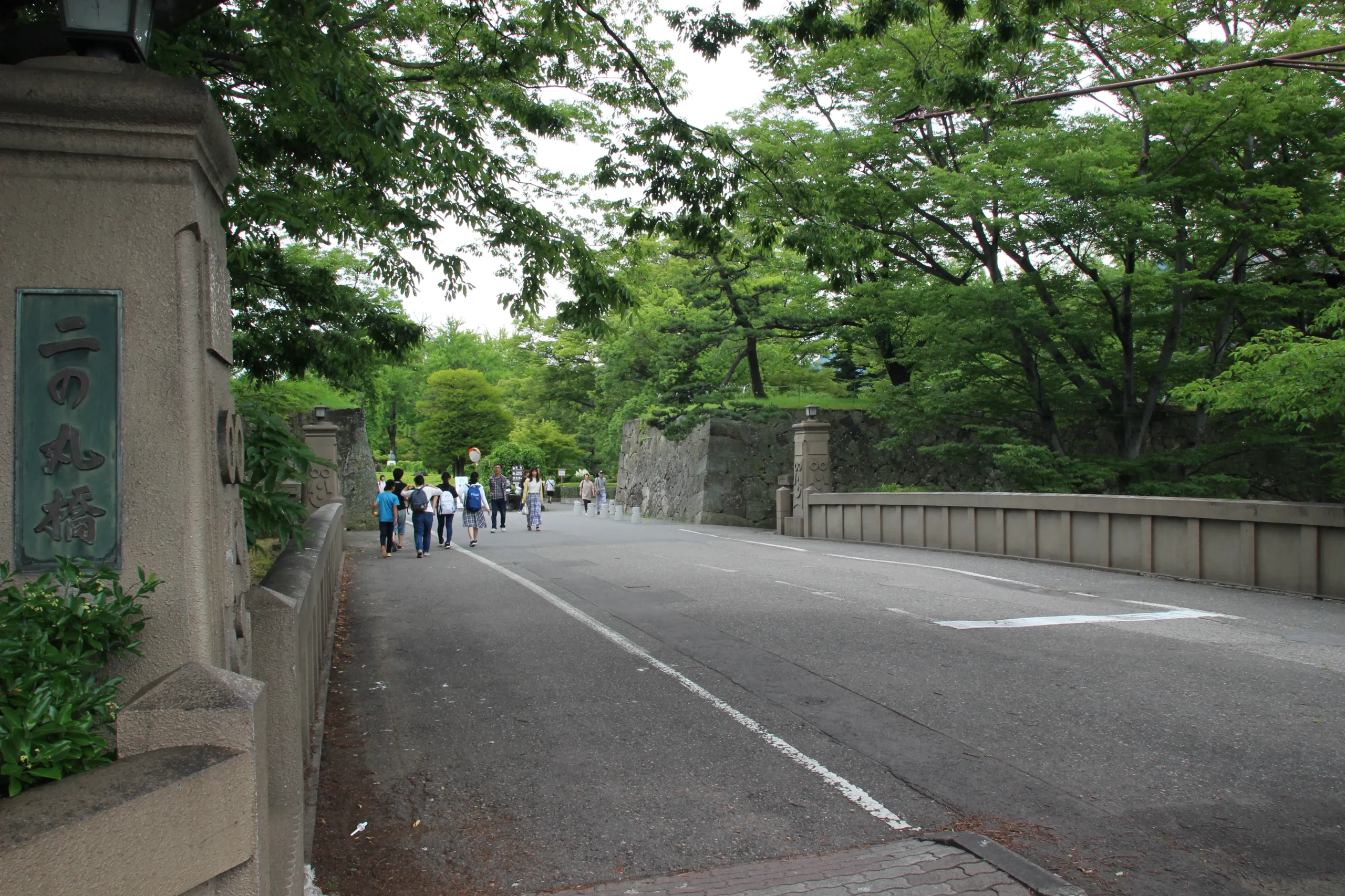 上田城二の丸跡へと続く二の丸橋と観光客が行き交うアスファルトの道路