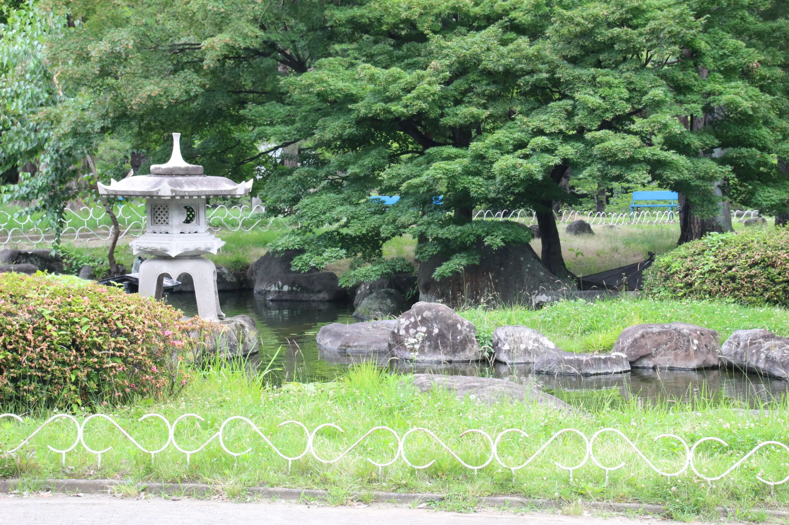 二の丸跡庭園の池に置かれた石灯籠と周囲を囲む新緑 of 豊かな自然