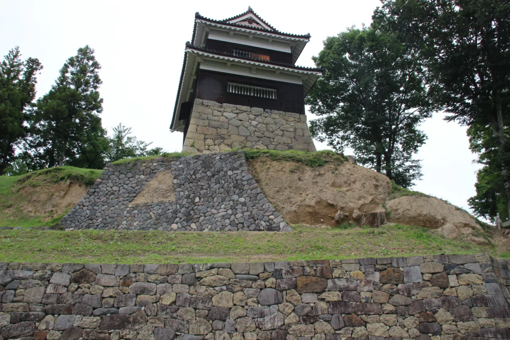 石垣の迫力ある積石と土塁の直下に建つ上田城西櫓のローアングル写真