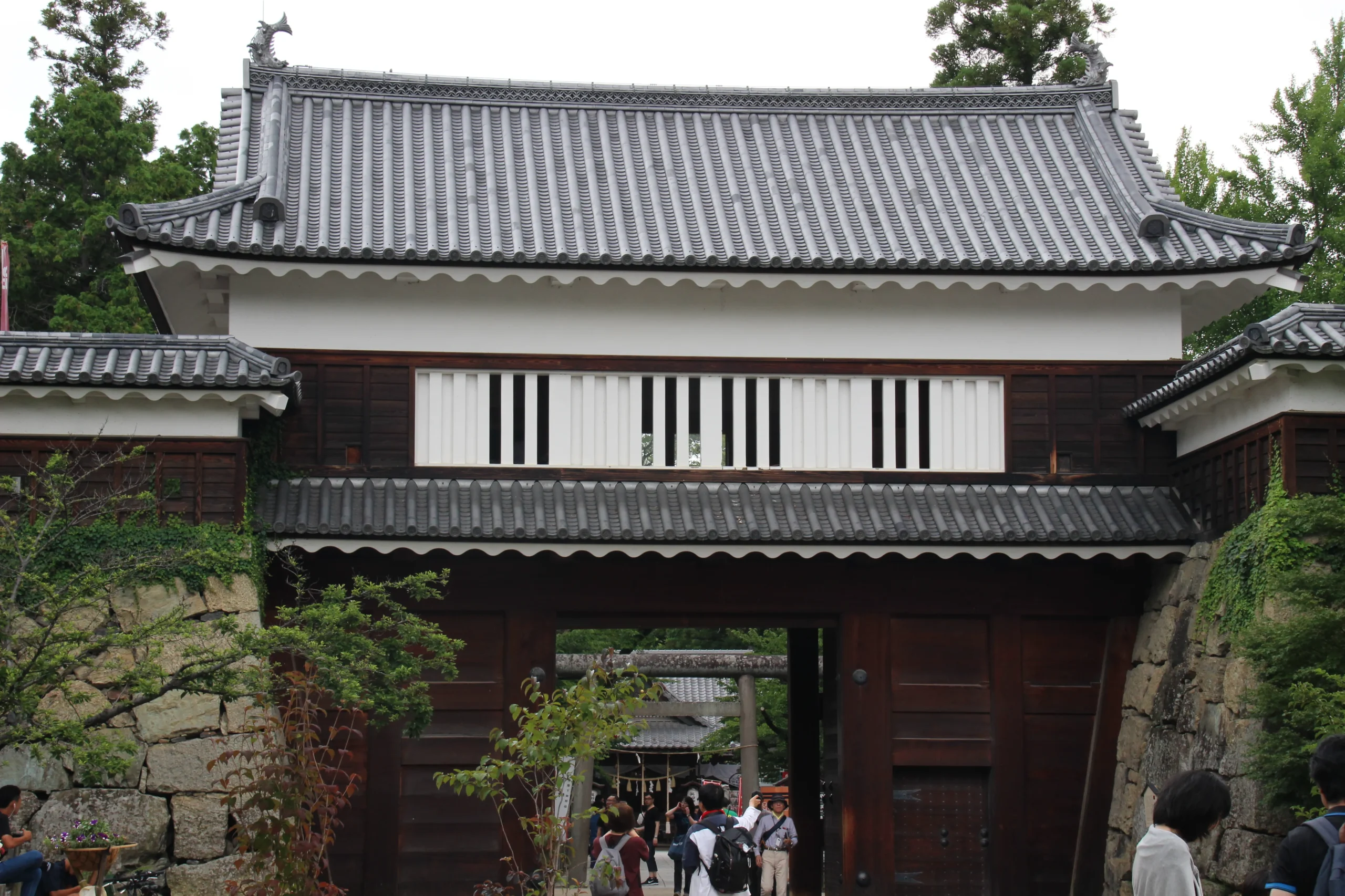 復元された東虎口櫓門の壮大な木造建築と黒い下見板張りの美しいデザイン