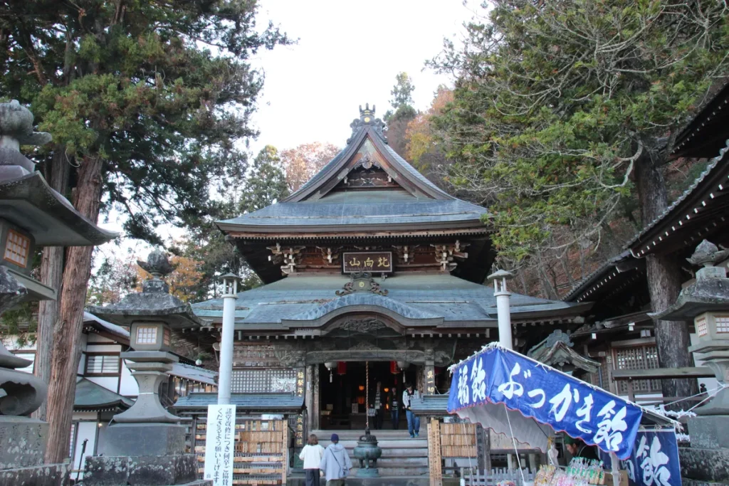 北向観音の本堂正面と、石灯籠やぶっかき飴の屋台が並ぶ風情ある参拝路の様子