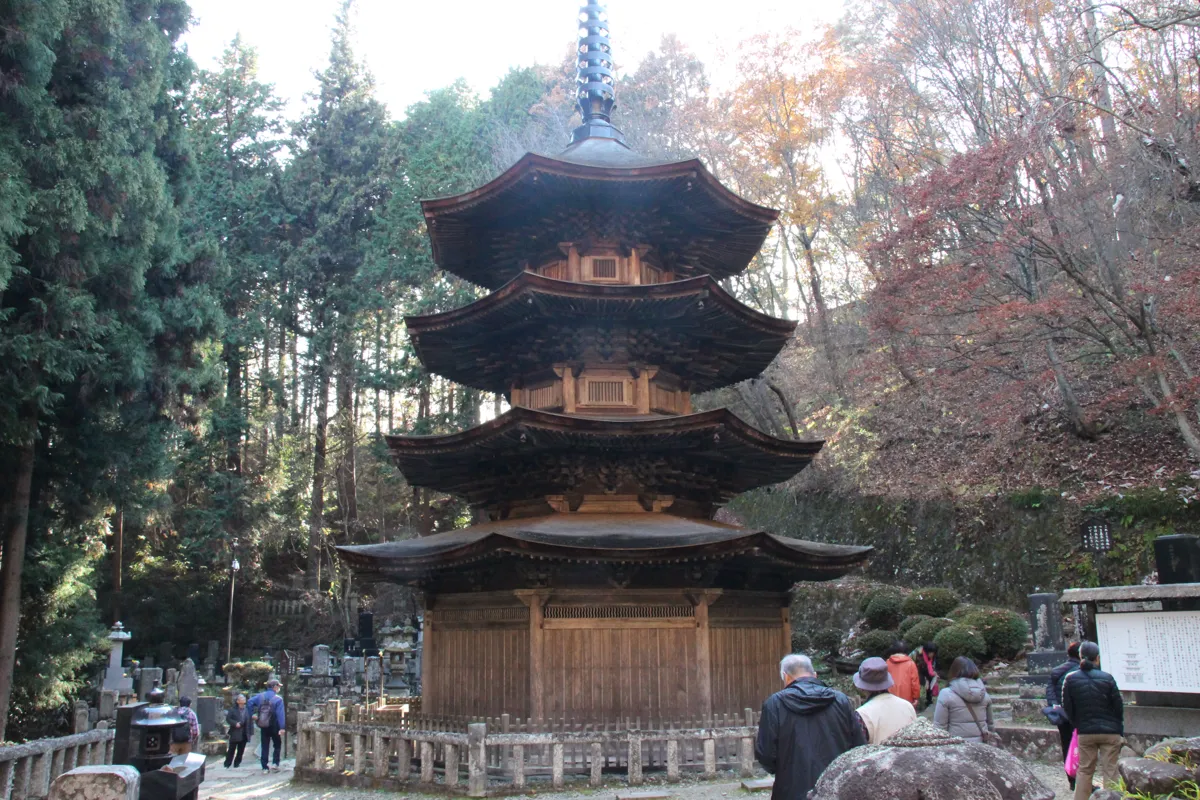八角三重塔の周囲を散策する参拝客と塔のスケール感がわかる景観