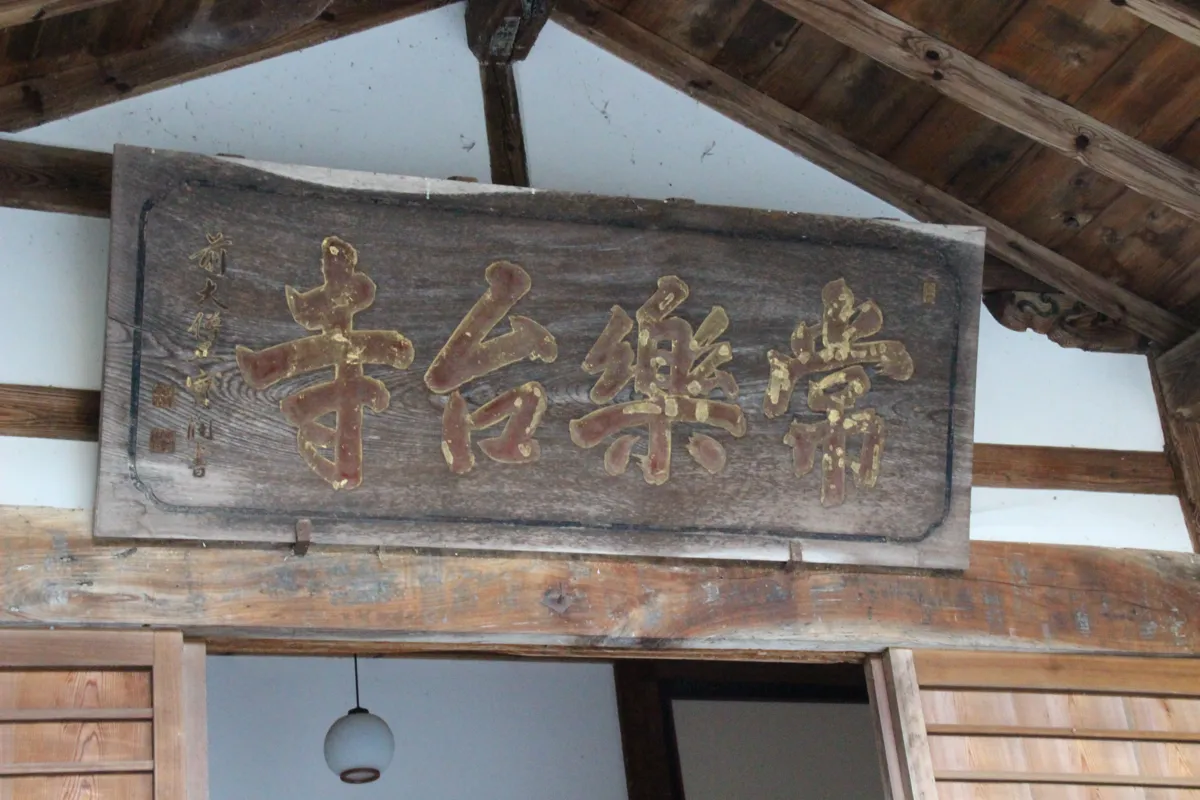 本堂の頭上に掲げられた右書きの力強い金文字の木製扁額「常樂台寺」のアップ
