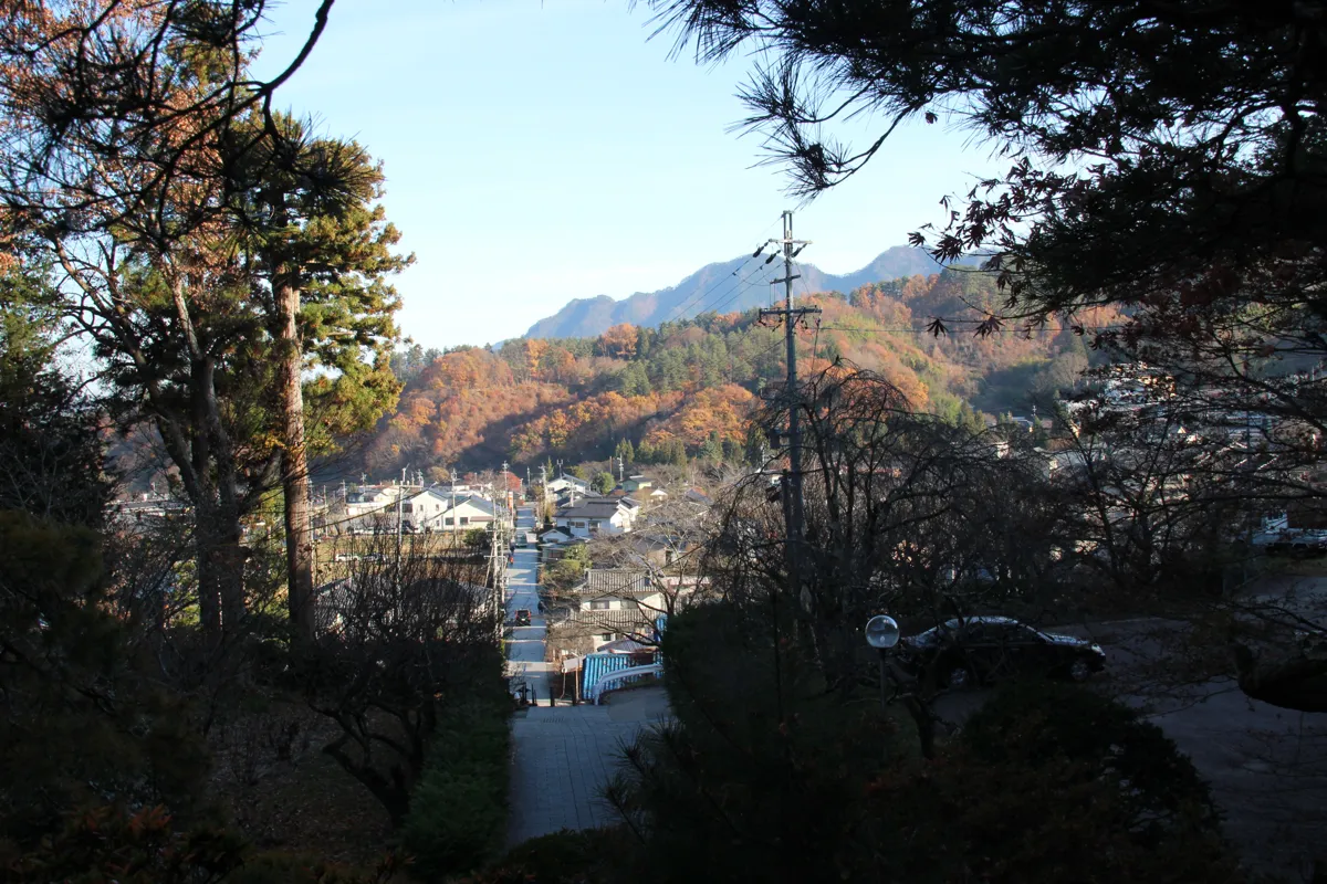 常楽寺の境内高台から見下ろす別所温泉の温泉街の街並みと遠くの山々の景観