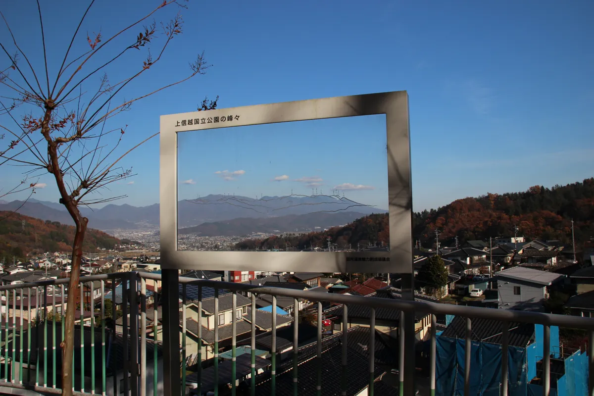 展望台の手すりに設置された、山名や標高が彫られた透明なアクリル製の眺望案内板