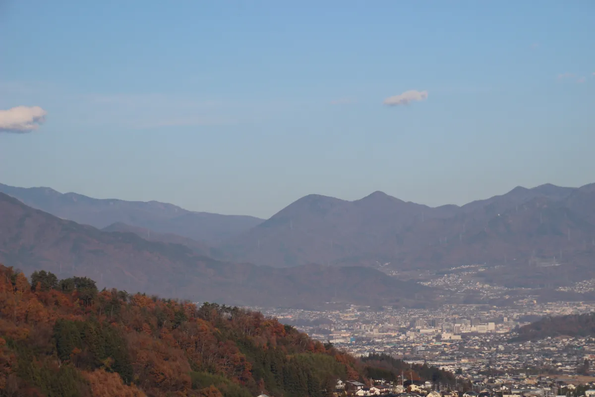 展望台から眼下に見下ろす塩田平の広大な平野と、北東にそびえる四阿山や太郎山の山影