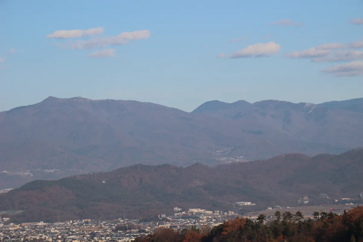 別所温泉遊歩道展望台から望む、青空と白い雲が広がる信州山岳の美しい全景