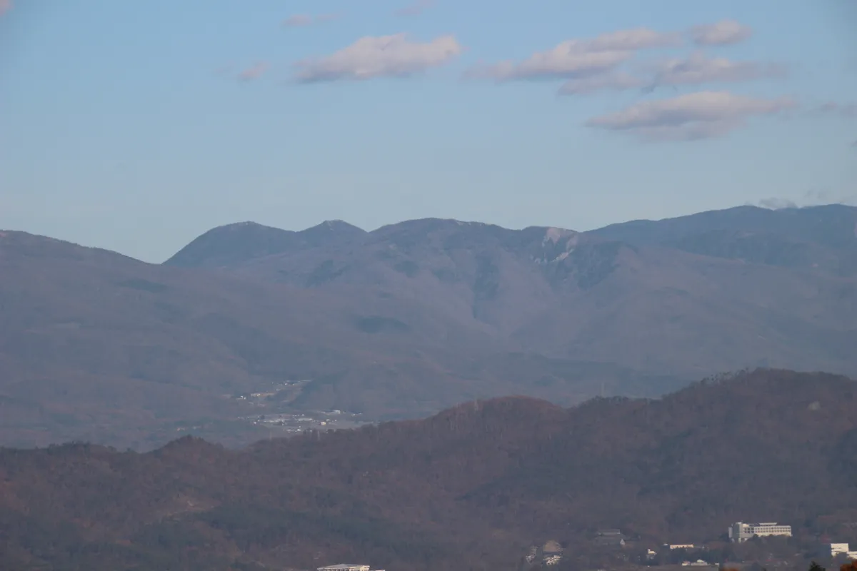 別所温泉の遊歩道から見上げる、澄み切った青空と連なる信州山脈の山容