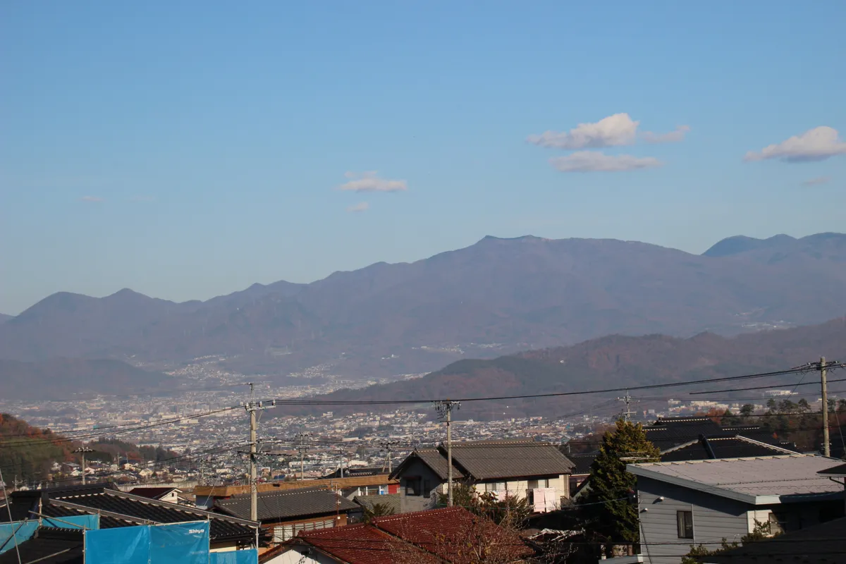 別所温泉遊歩道展望台から眼下に望む塩田平の田園地帯と上田盆地、遠方の山並み