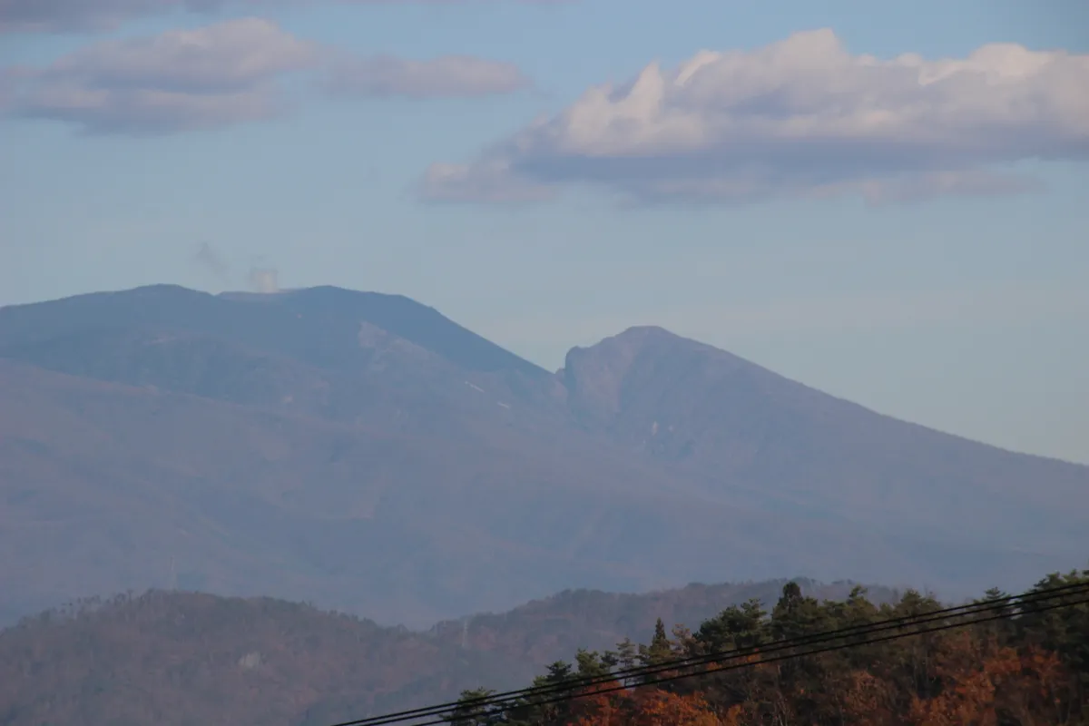 青空と白い雲を背に美しく連なる、長野県上田市の穏やかな山々の稜線