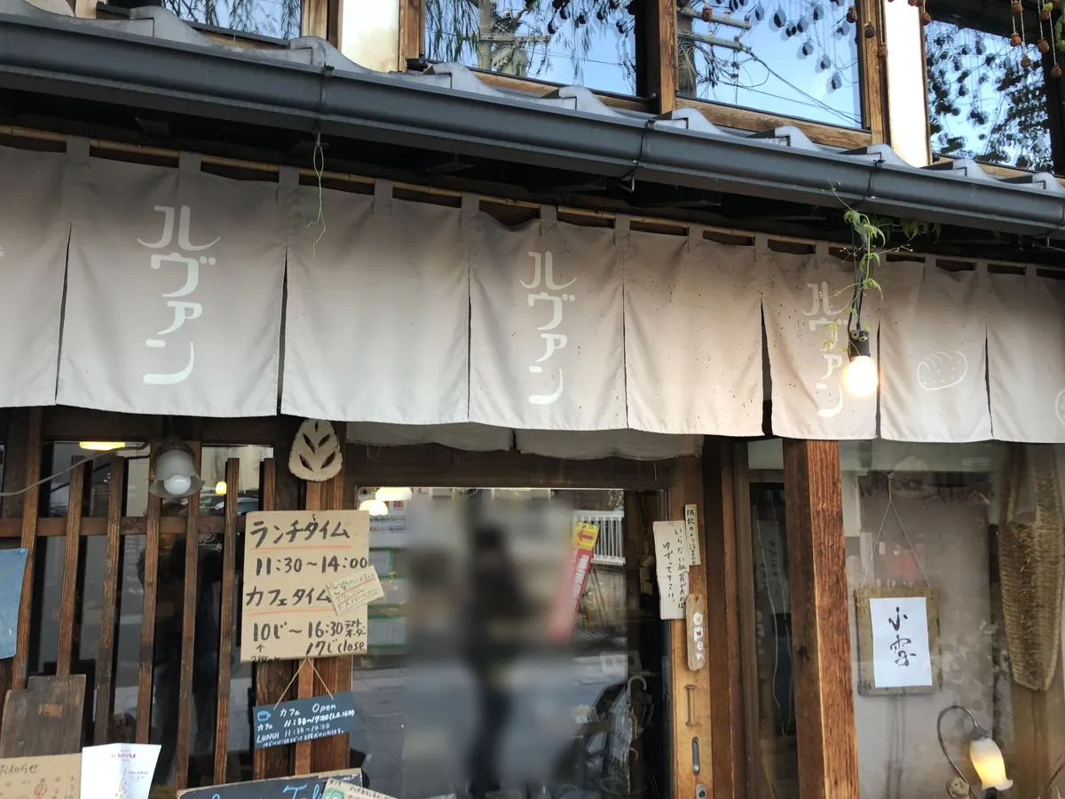 「ルヴァン」の白い文字が染め抜かれた素朴な暖簾が下がる、ルヴァン信州上田店の店舗入口と古い引き戸のアップ