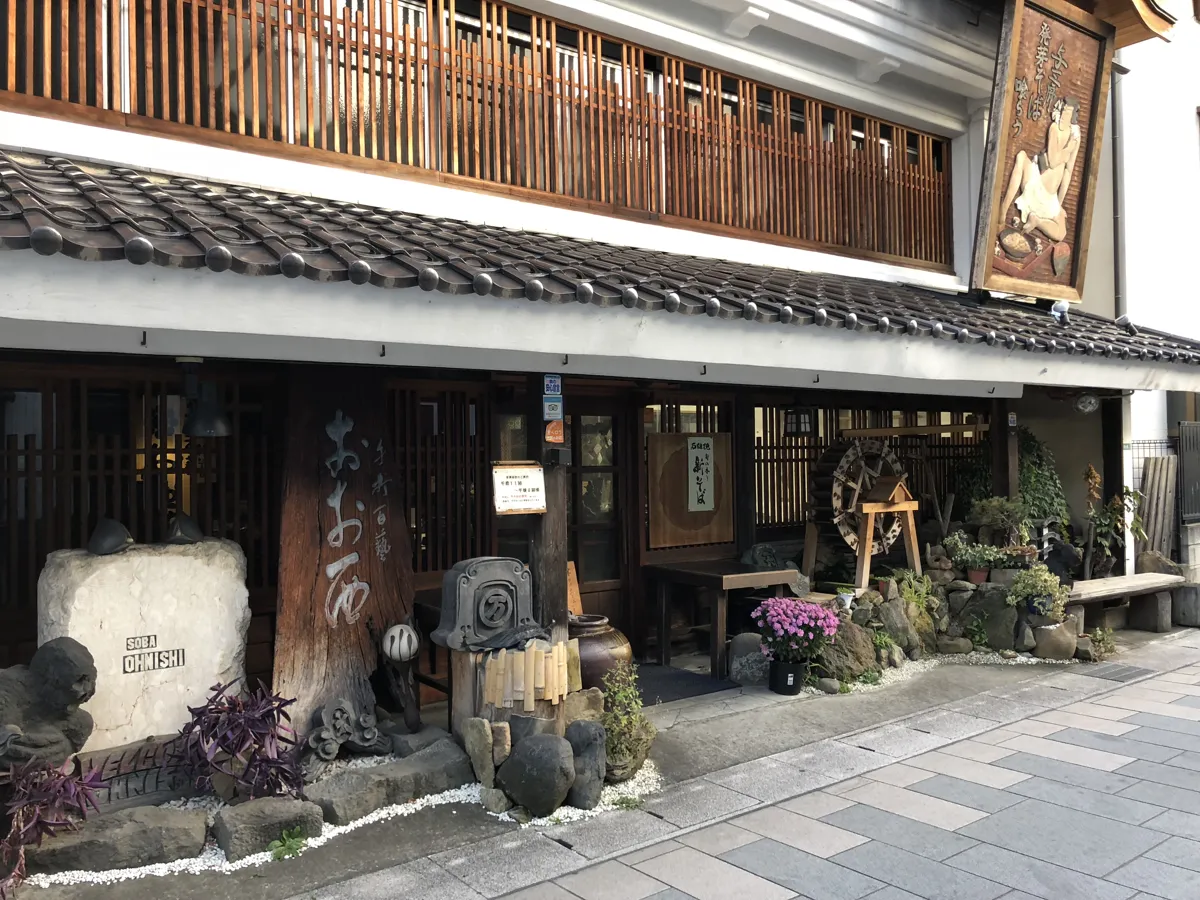 そば打ちの伝統を伝える大きな看板が目印の、柳町通りにあるそばの名店「十割百藝 おおにし」の趣ある建物正面