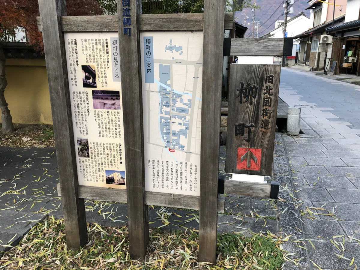 柳町通りの入り口付近に設置された、通り沿いの歴史的見どころや名店を網羅した木製の詳細な観光案内看板