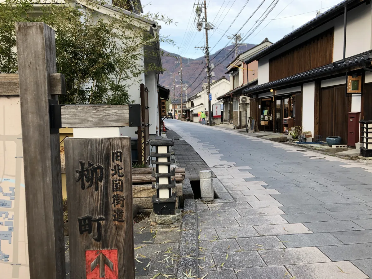 木製の「旧北国街道 柳町通り」の標柱が佇む、情緒あふれる通り沿いの散策路の景観